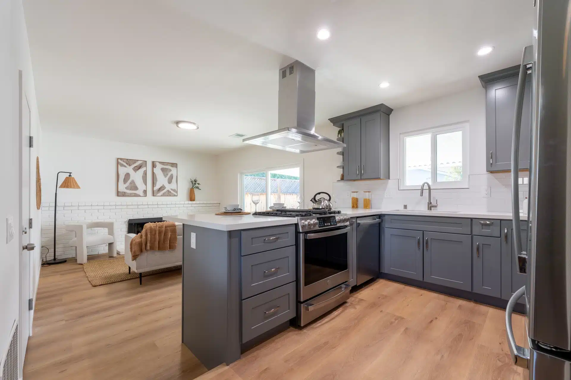 Open-plan grey shaker kitchen with a peninsula opening onto the living area