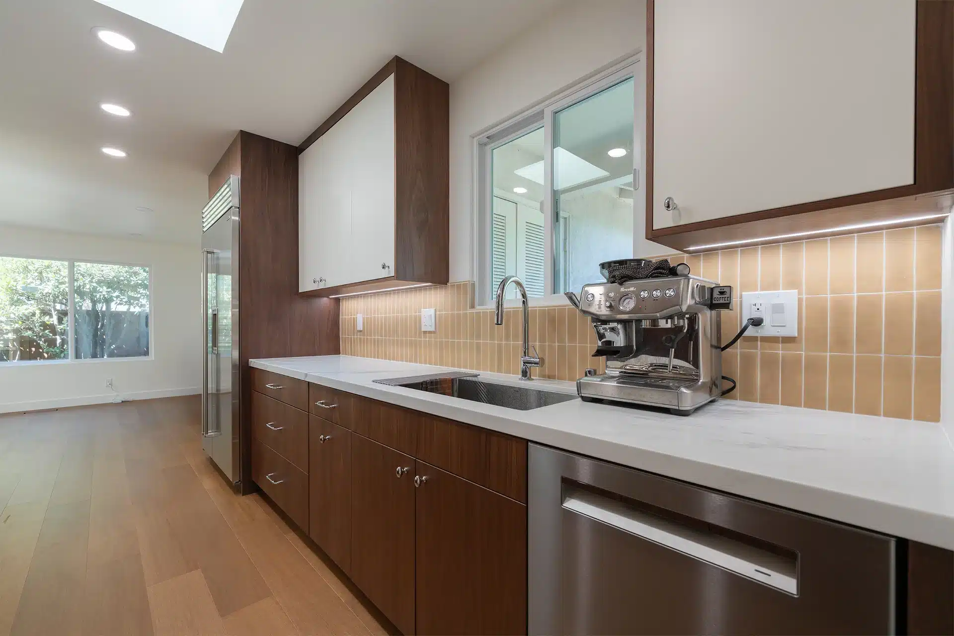 Tan vertical stack tile behind a prep counter with white upper cabinets