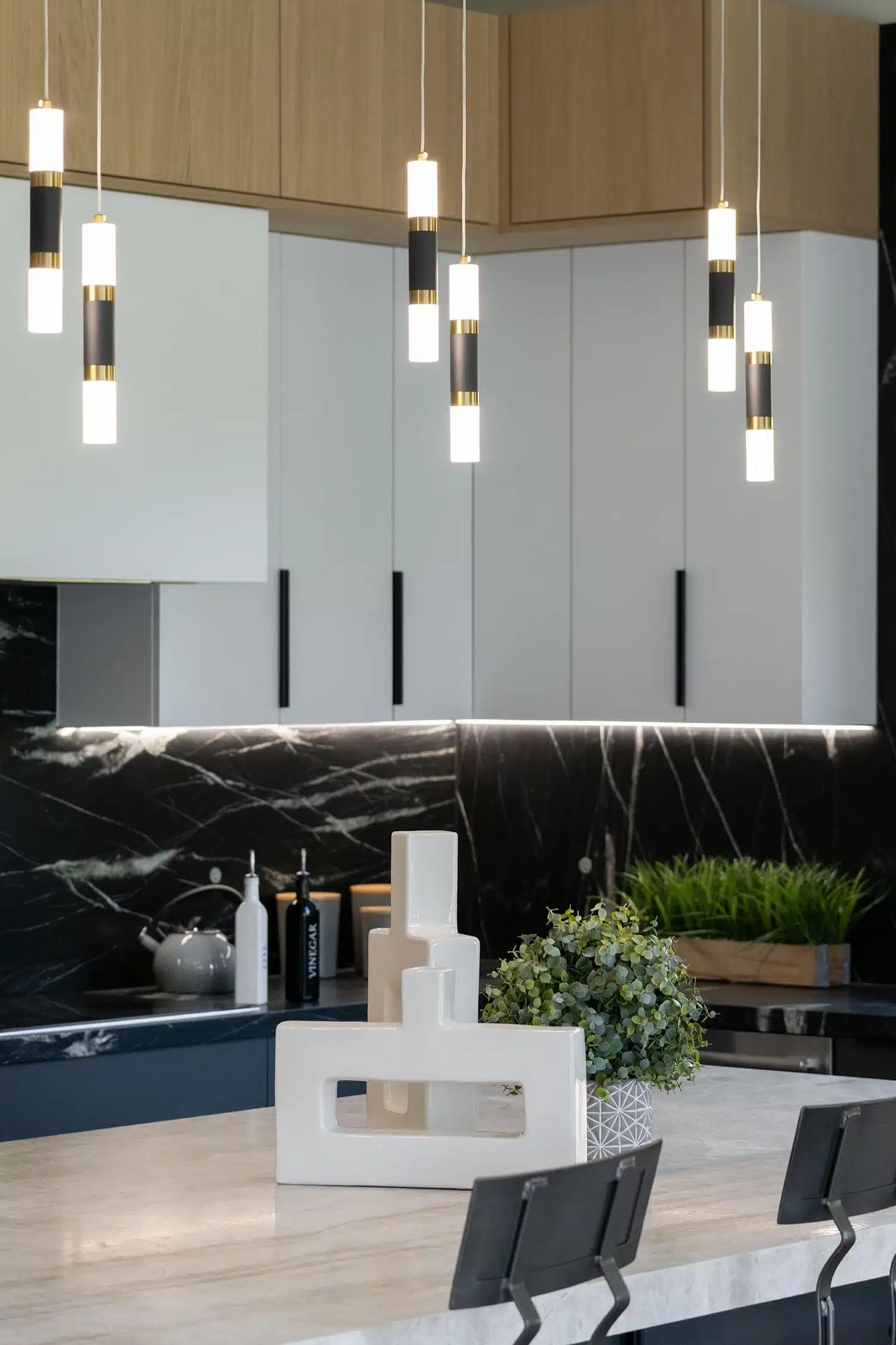Cylinder pendants hanging over a travertine kitchen island